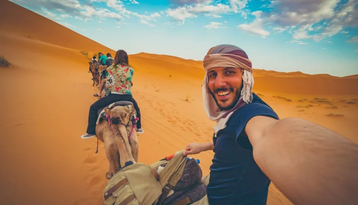 happy-nomad-man-taking-crazy-selfie-during-camel--2048x1365