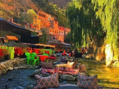 a river with tables and chairs and a mountain in the background