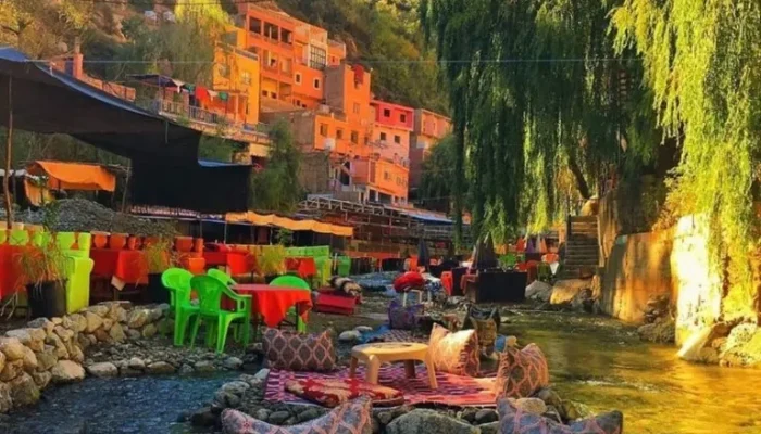 a river with tables and chairs and a mountain in the background