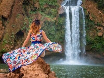 Beautiful waterfall in Morocco. Back woman beautiful dress looking fall Ouzoud Grand Atlas. Exotic nature North Africa