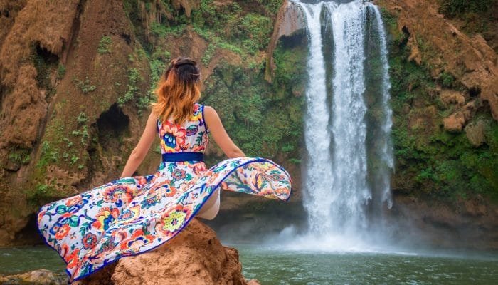 Beautiful waterfall in Morocco. Back woman beautiful dress looking fall Ouzoud Grand Atlas. Exotic nature North Africa