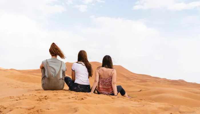 a group of people sitting in the sand